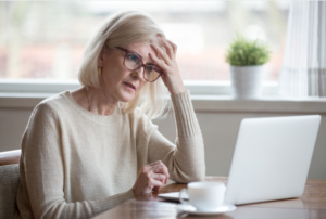 Older woman in front of a computer looking frustrated