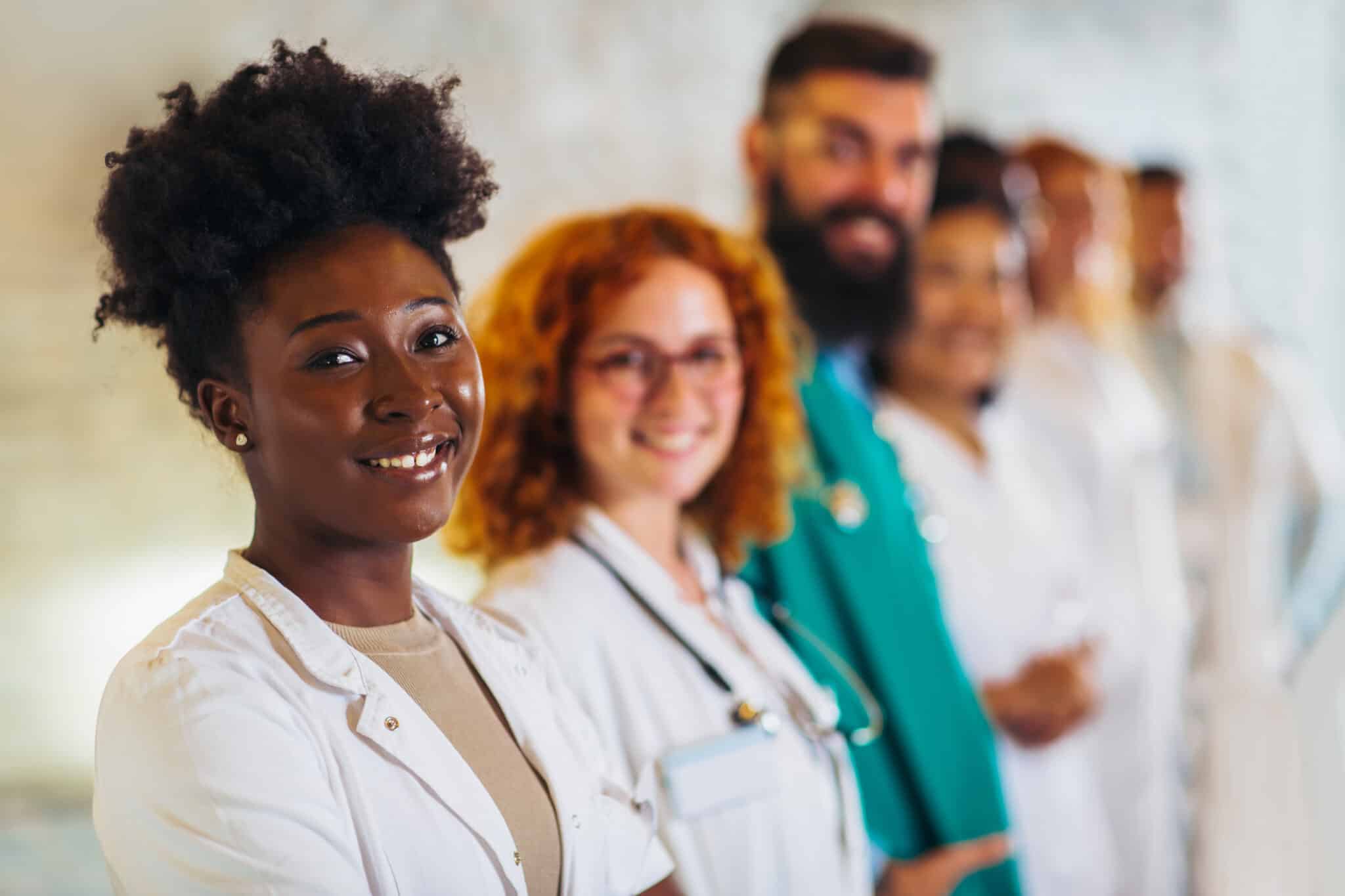 hospital, profession, people and medicine concept - group of happy doctors at hospital